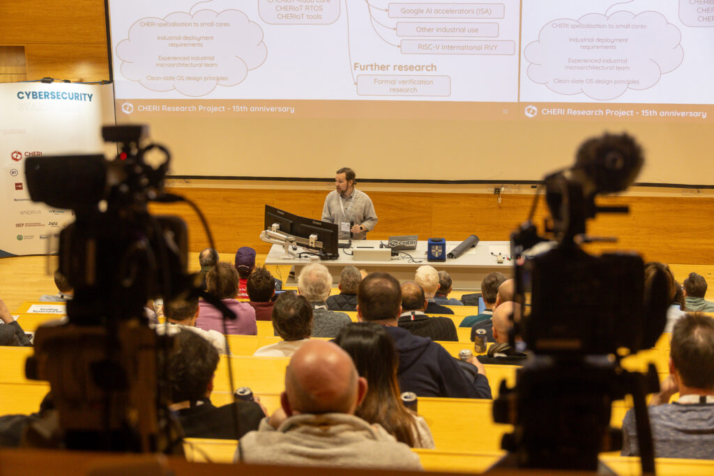 Robert Watson giving a talk at CHERI Blossoms 2026